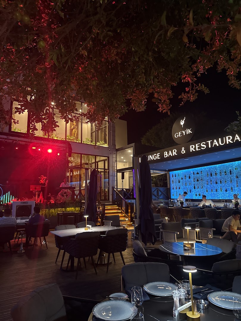 Bahçe sahnesinde canlı müzik, arkada aydınlatılmış bar