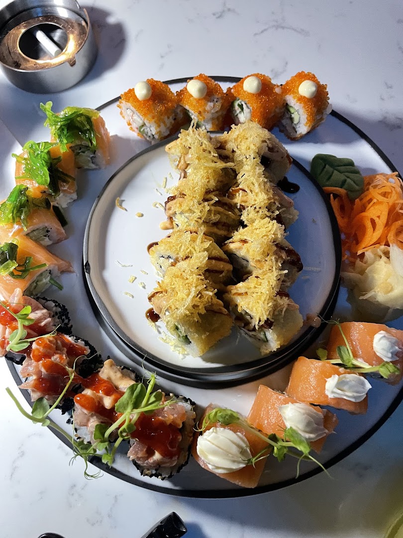 Geniş sushi tabağı, somon ve kızarmış rulolarla