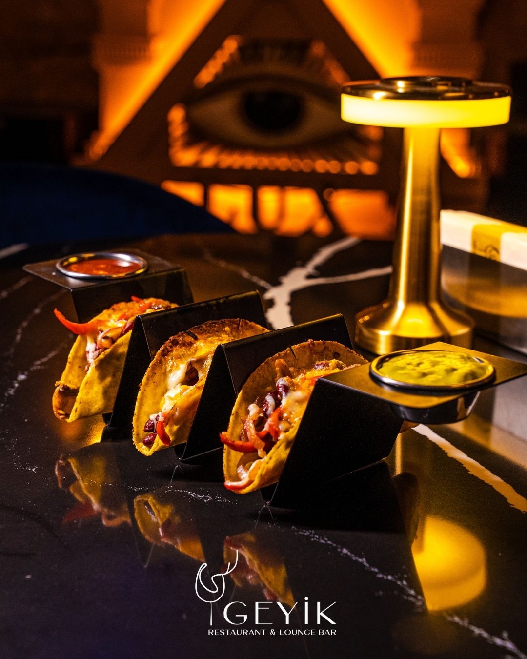 Siyah mermer masada taco sunumu ve altın masa lambası